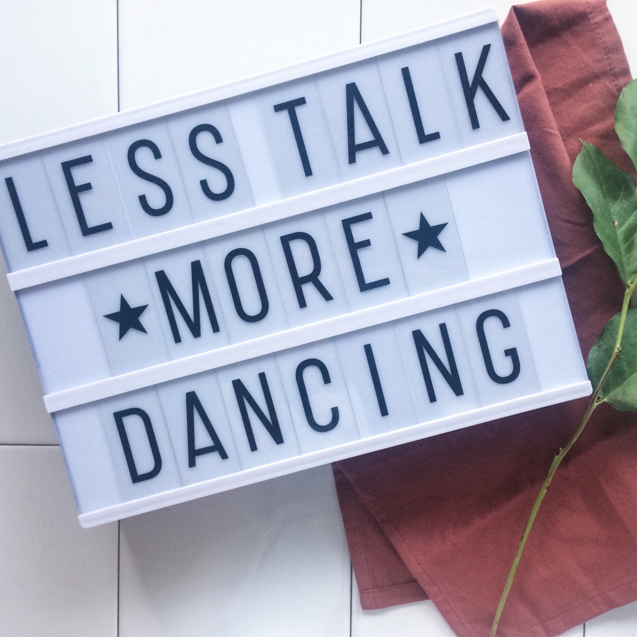 Lightbox quote: less talking more dancing met rood katoenen servet en tak