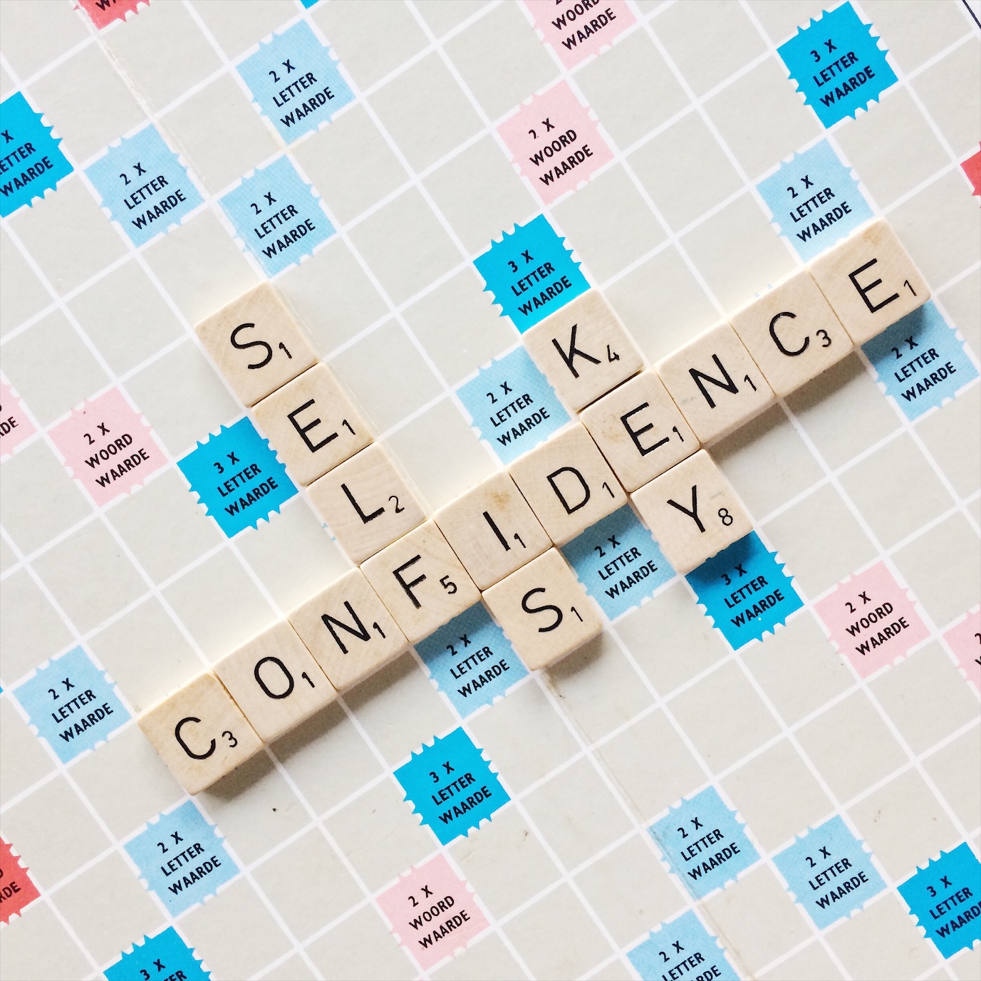 Flatlay van scrabble bord met quote self confidence is key, het tegengif voor perfectionisme ;)